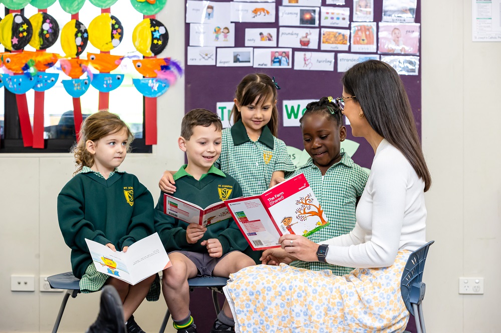 Shared reading activity with students and an adult in a classroom.