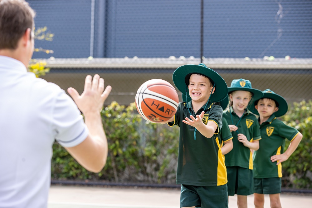 Students practising ball skills during an outdoor physical education lesson.