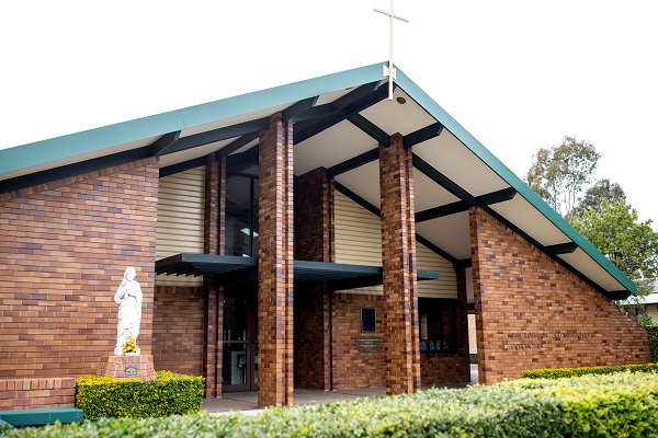 Exterior view of a brick Catholic church building.